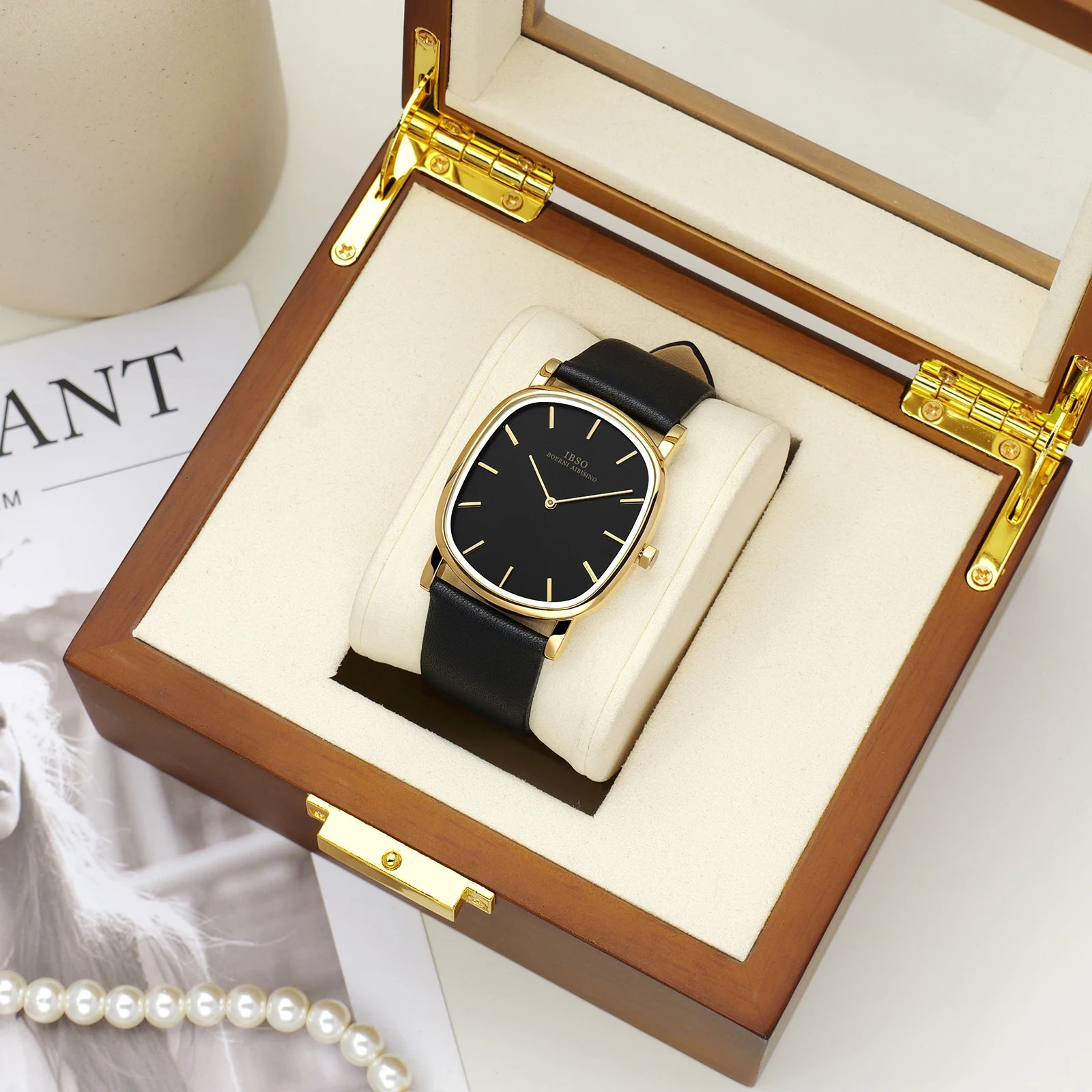 IBSO men's luxury gold and black minimalist watch beautifully presented on a white pillow inside a premium wooden gift box.