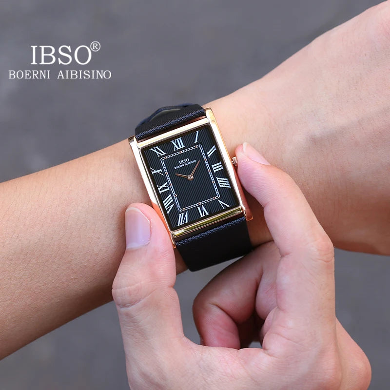 A close-up view of a man's wrist checking his gold IBSO rectangular dress watch featuring a sharp black dial with white Roman numerals