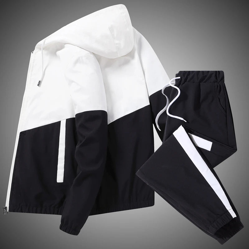 Studio catalogue presentation showcasing the black and white full-zip tracksuit layout with integrated storage pockets and clean stitched cuffs