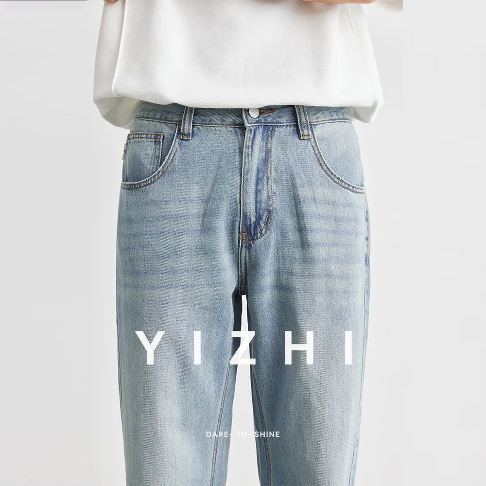 Close-up crop of a model wearing the light blue denim trousers, showcasing the mid-rise waist layout, button fly, and vintage whiskering pattern details