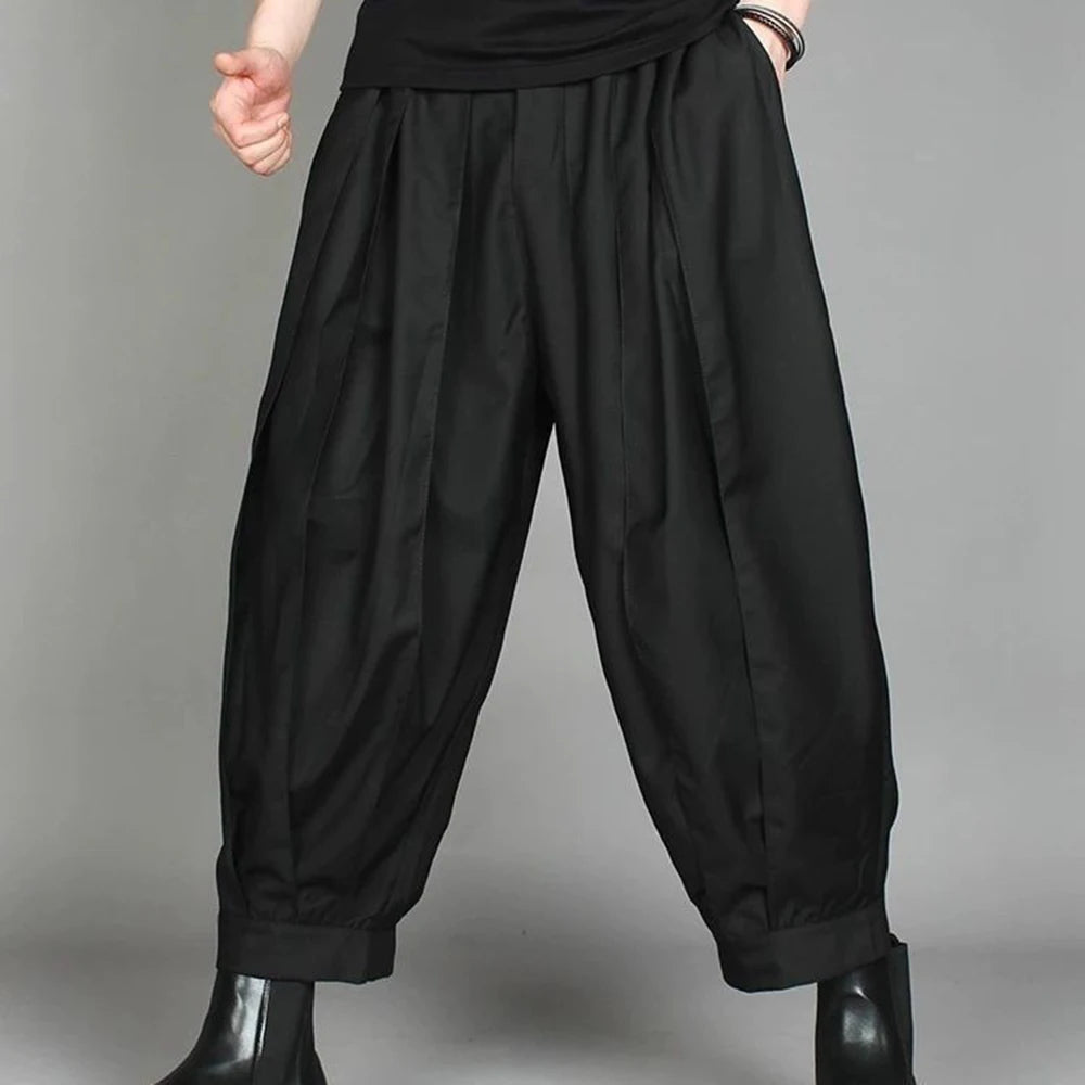 Model showcasing the wide leg techwear movement and ankle-length cut of the black harem trousers