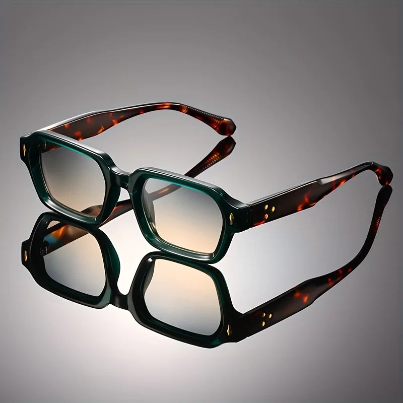Retro chunky rectangular sunglasses featuring a green translucent front, tortoiseshell temples, and gradient lenses on a reflective surface.