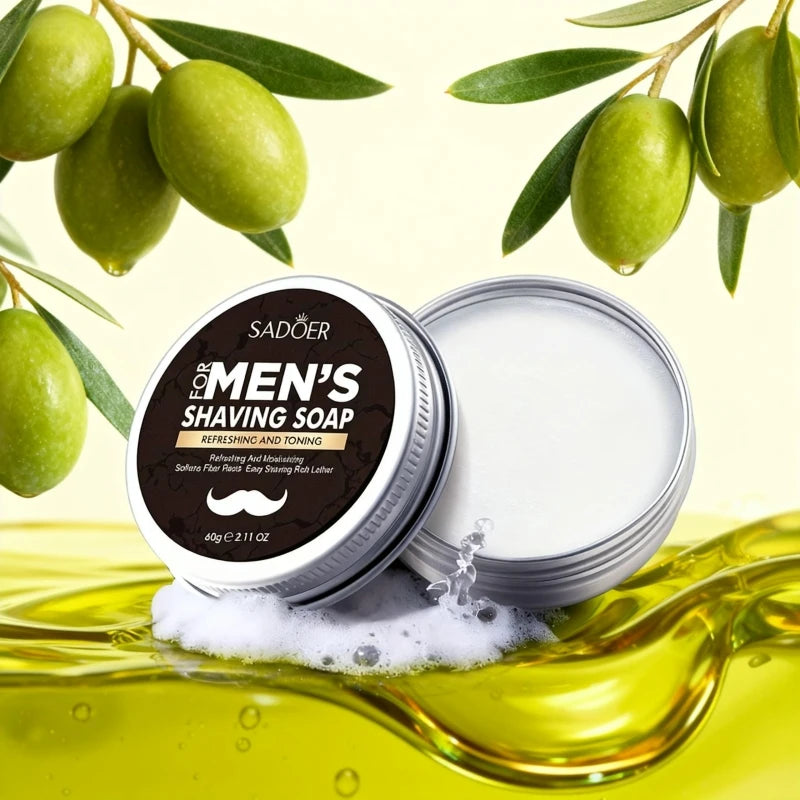Sadoer shaving soap puck surrounded by fresh green olives, olive oil splashes, and mint leaves