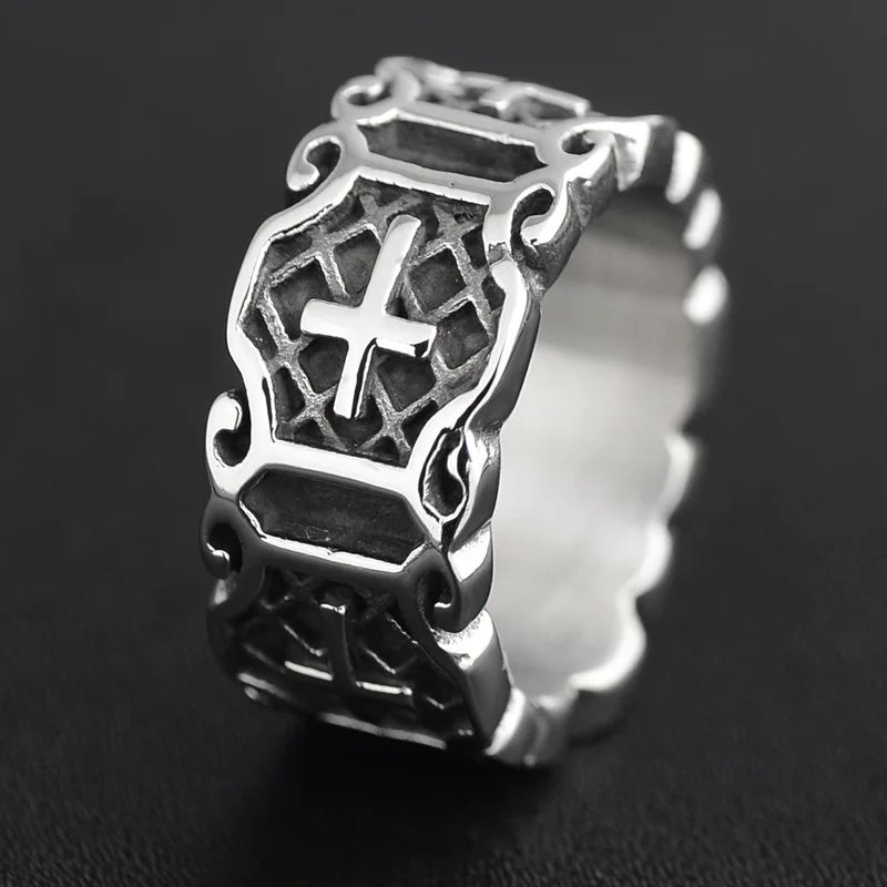 Close-up view of a silver gothic cross punk ring highlighting the textured black background behind the silver crosses.