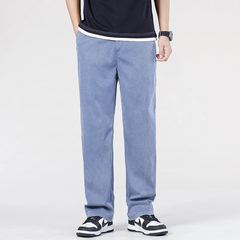 Front view of a model showcasing the casual flowing silhouette of the light blue broadcloth knit Lyocell summer pants paired with chunky black and white sneakers