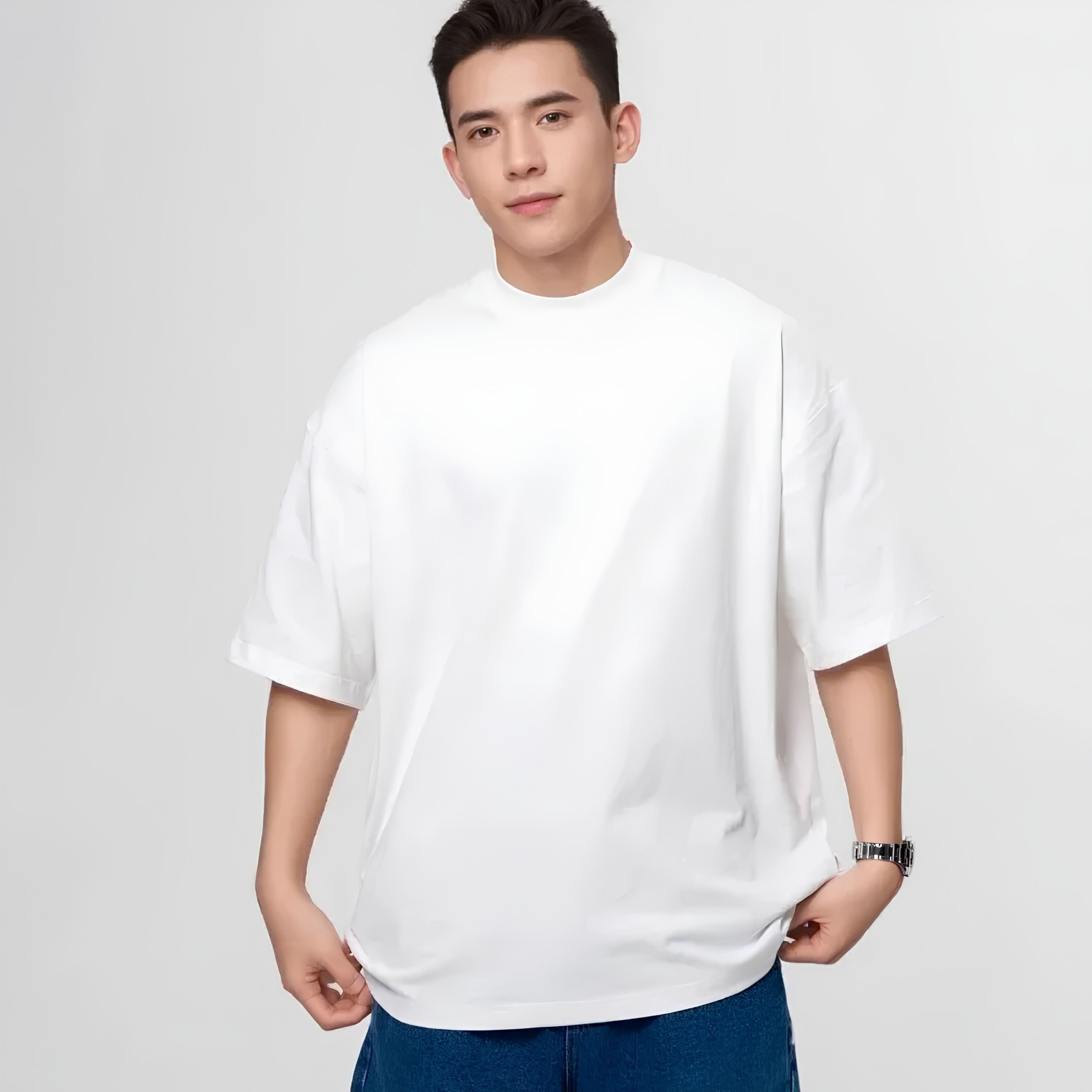Front view of a male model posing in the boxy architectural drape 100% cotton t-shirt in solid classic white
