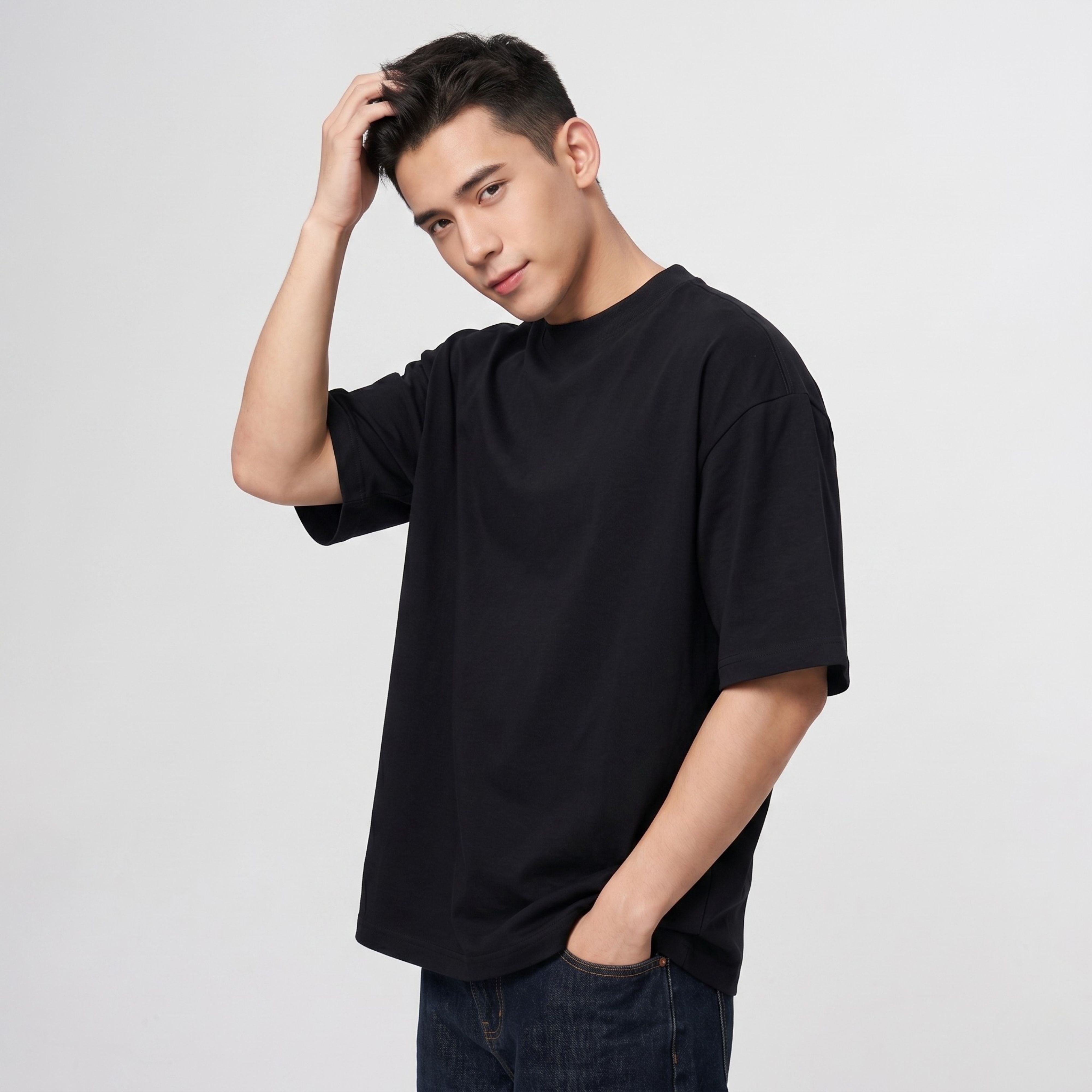 A male model running his hand through his hair while modeling the heavy broadcloth casual t-shirt in solid black