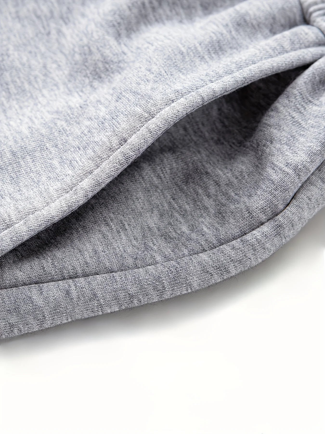 Macro close-up shot of the double-sided deep side pocket on the heather grey knitted sweatpants, showcasing the clean seam construction