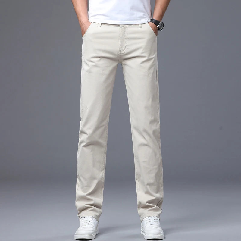 Front view of a male model modeling the off-white beige  ivory mid-rise straight leg jeans, styled with white casual tennis shoes for a clean business daily look