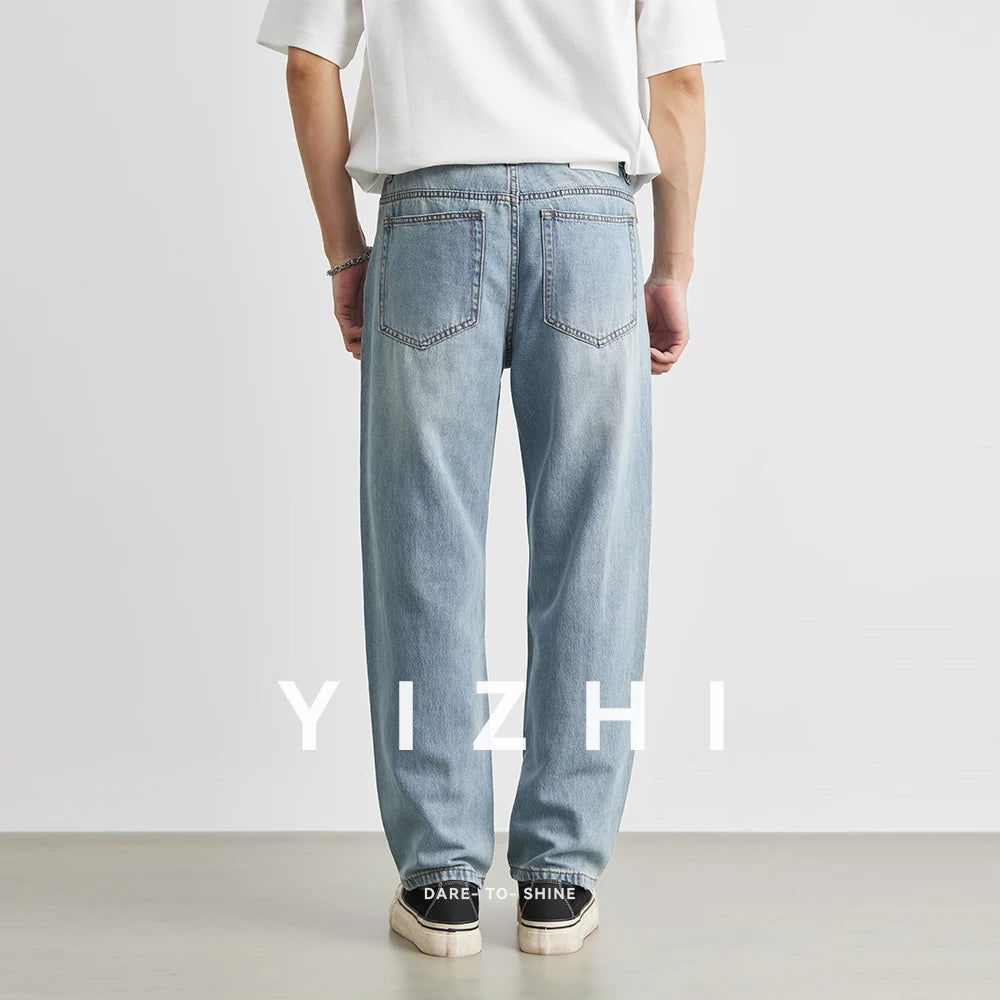 Full rear view of a male model showing the back pockets, mid-rise waist, and relaxed loose fit of the straight light blue jeans