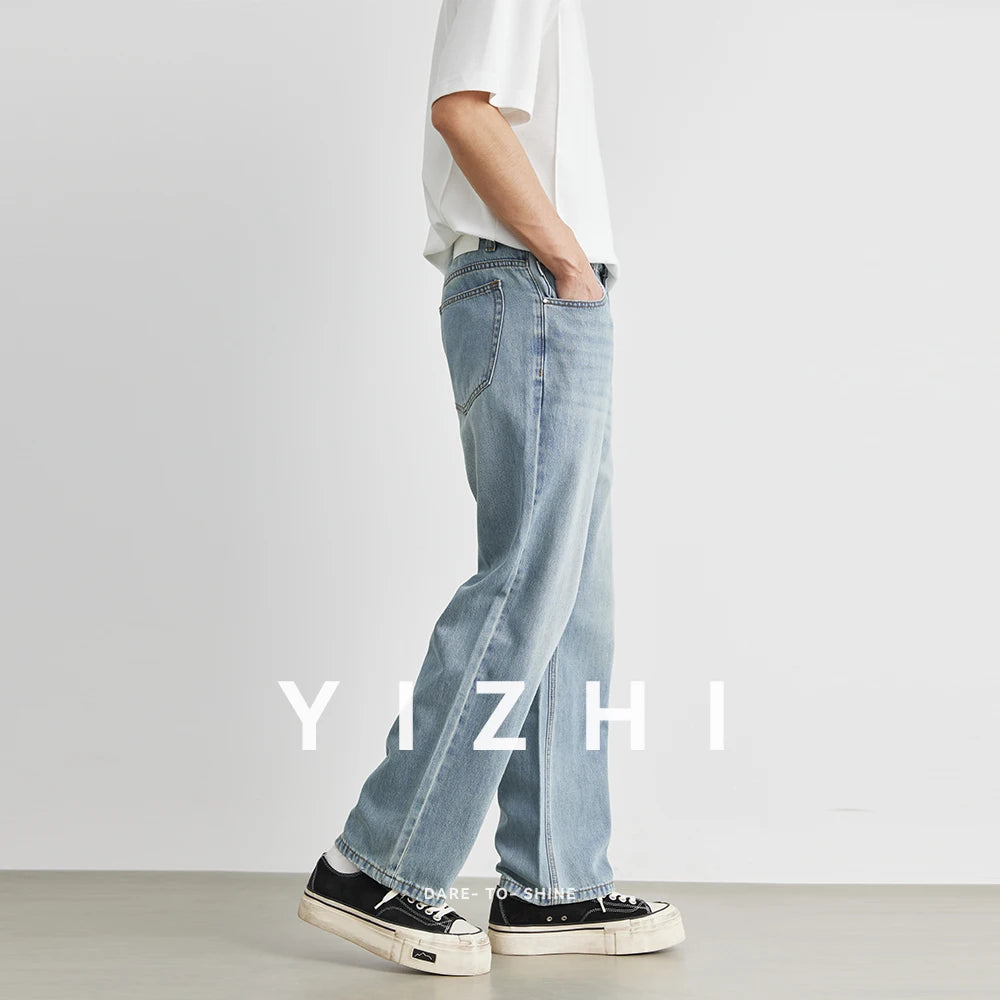 Side profile walking view of a male model displaying the relaxed flowing silhouette and straight-leg drape of the light wash loose jeans
