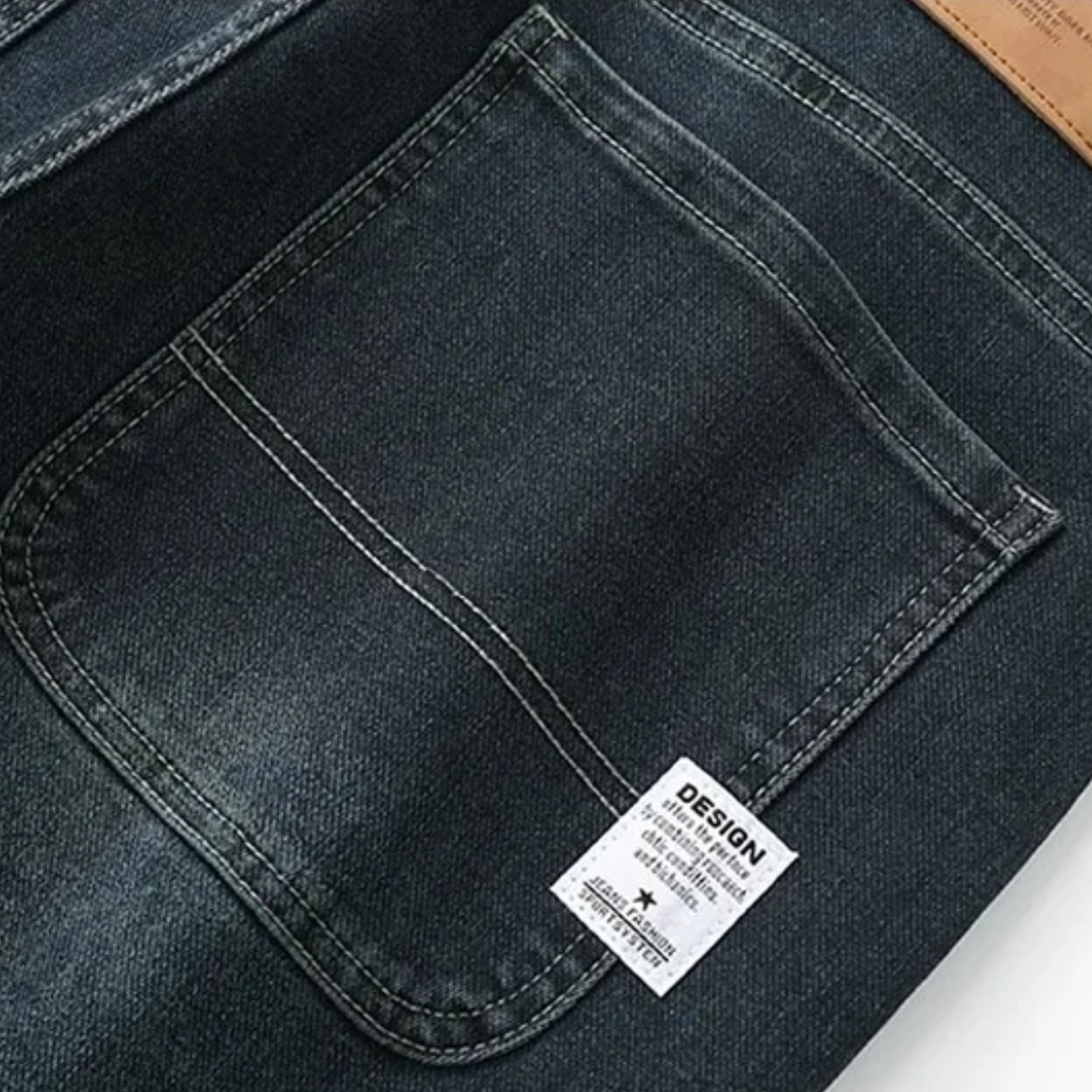 Detailed view of the rear pocket construction featuring a modern white graphic design fabric tag stitched near the lower hem