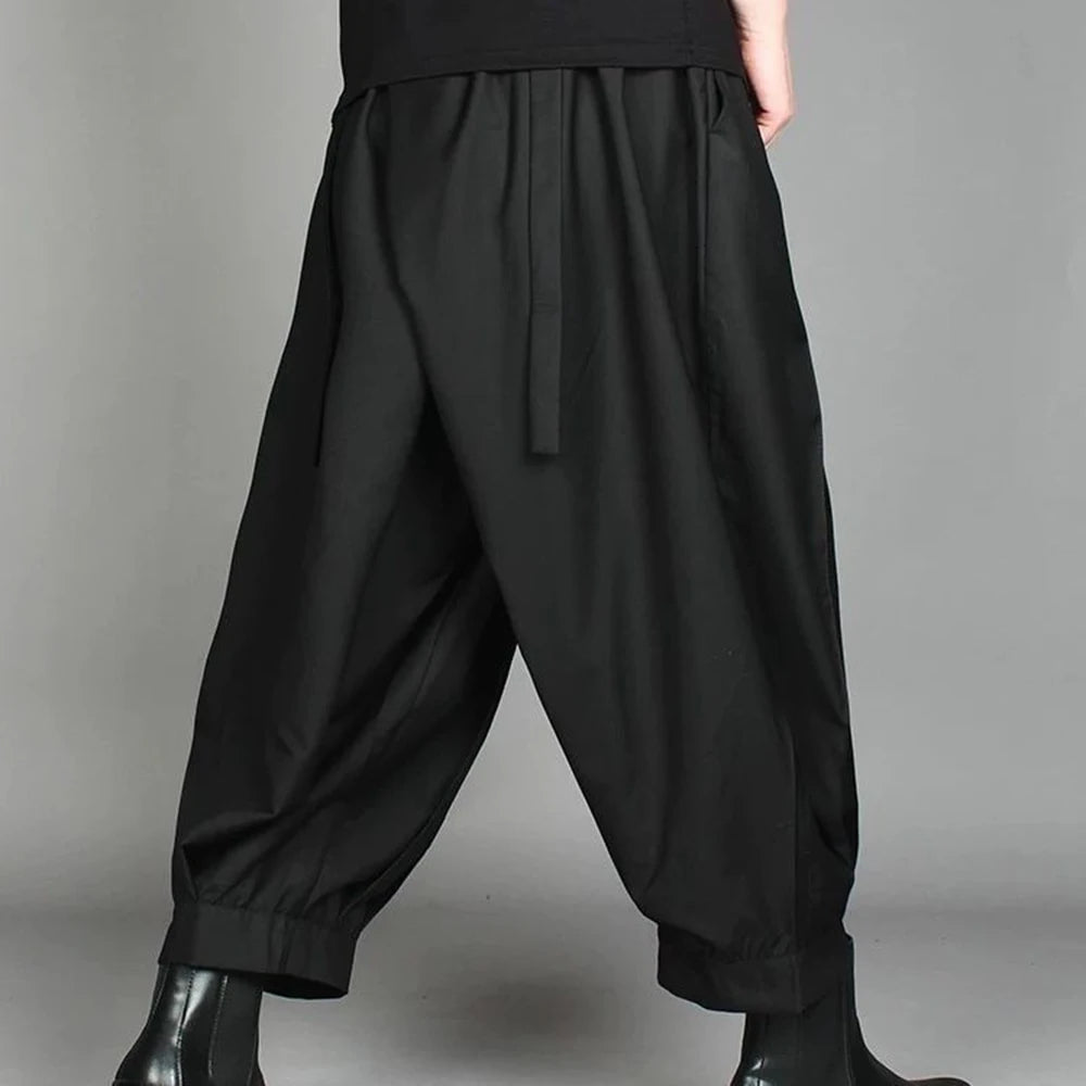 Back view of men's loose pleated casual pants showing the premium knit fabric flow