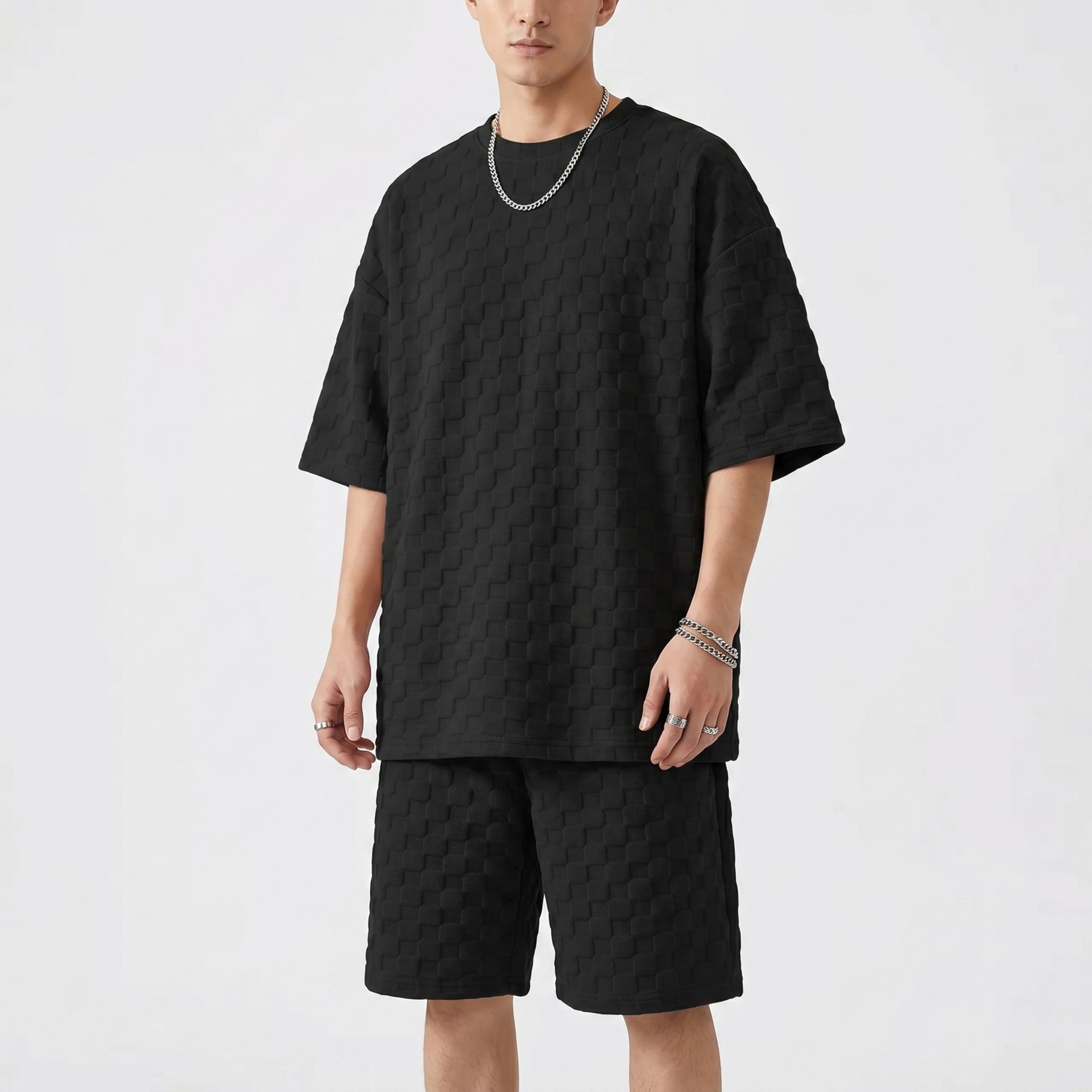A male model posing in the retro loose black jacquard plaid co-ord set, highlighting the standard thickness drape of the streetwear outfit