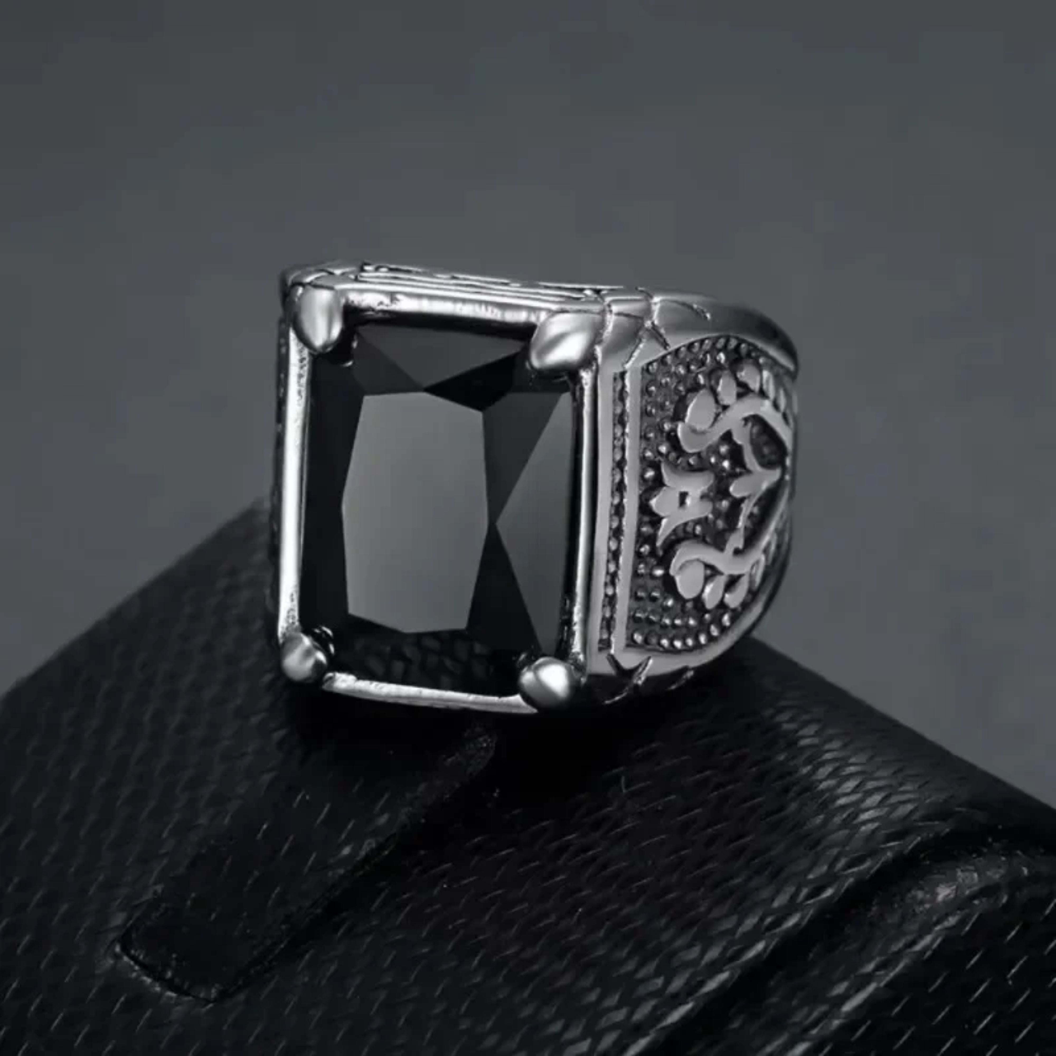 Men's retro silver ring with a large black stone displayed on a black leather ring box.