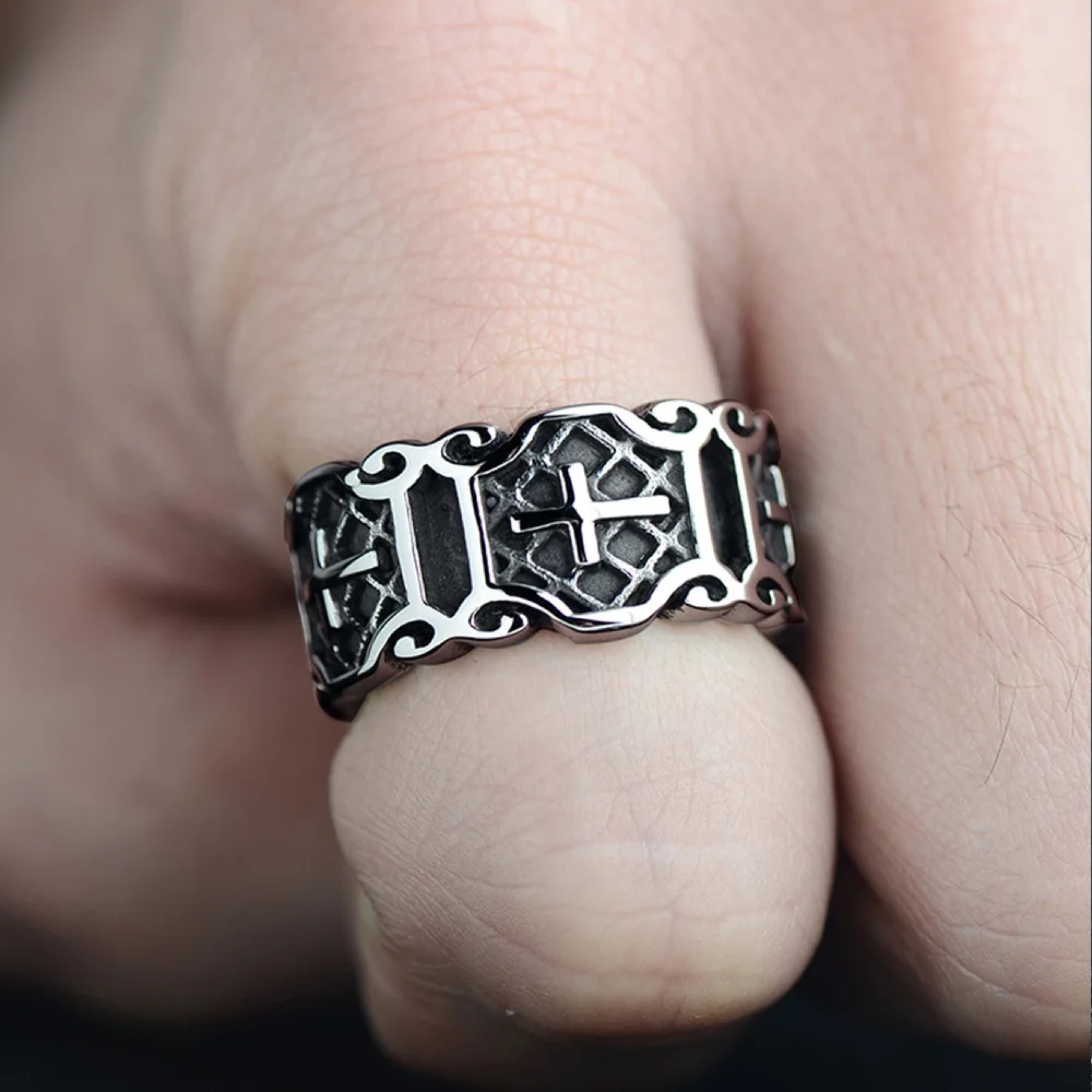 Close-up of a man wearing the chunky silver gothic cross ring on his thumb, highlighting its large scale and fit.