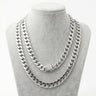 Two thick men's silver Miami Cuban link chains of varying lengths displayed on a grey velvet jewelry bust.