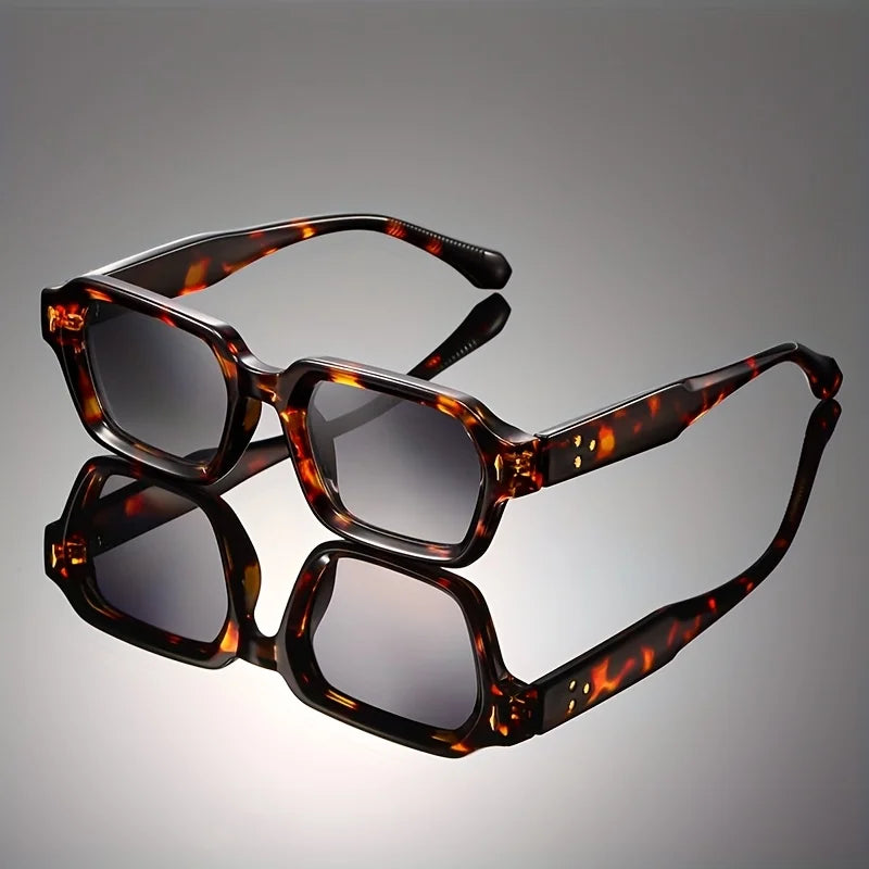 Retro chunky rectangular sunglasses with a full brown tortoiseshell acetate frame and dark lenses reflecting on a dark studio background.