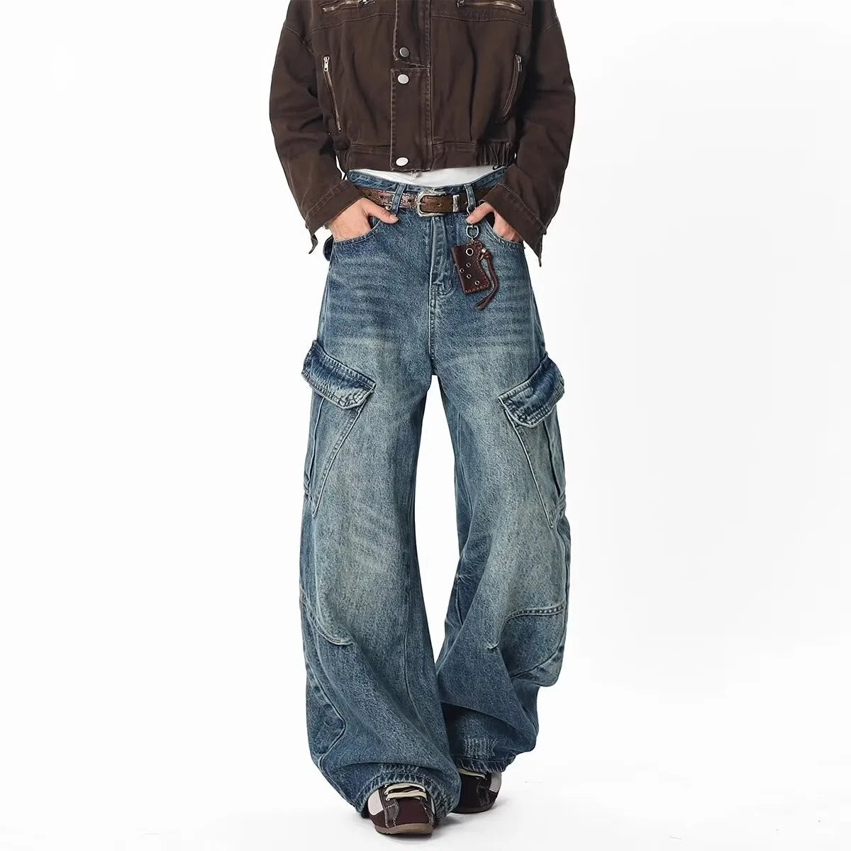 Full length front view of a model styling distressed blue baggy cargo denim pants with side utility pockets