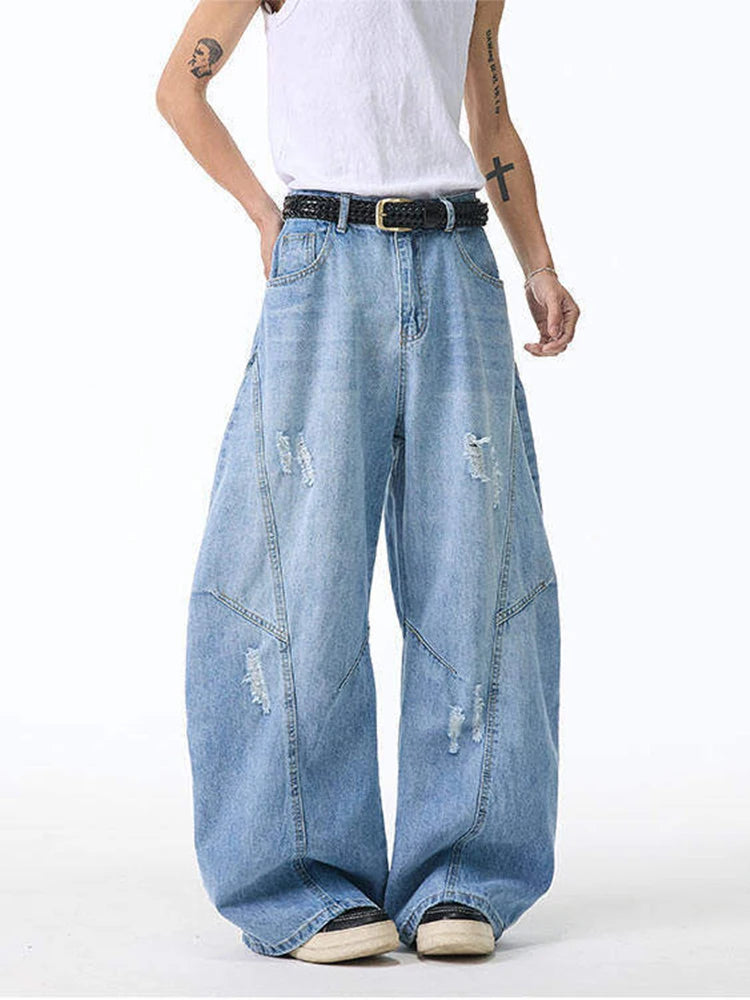 Model wearing light blue relaxed fit jeans with an elastic-style dark waistband accent and vertical panel lines